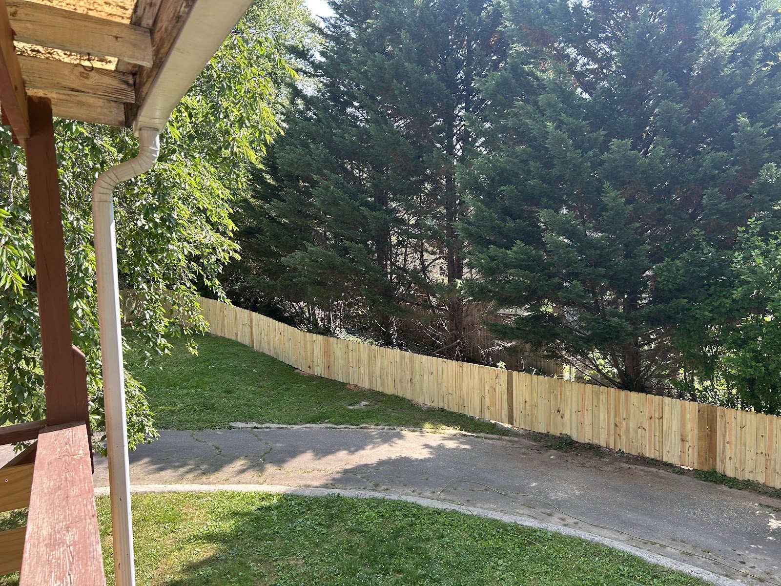 Wood picket fence following a sloped driveway