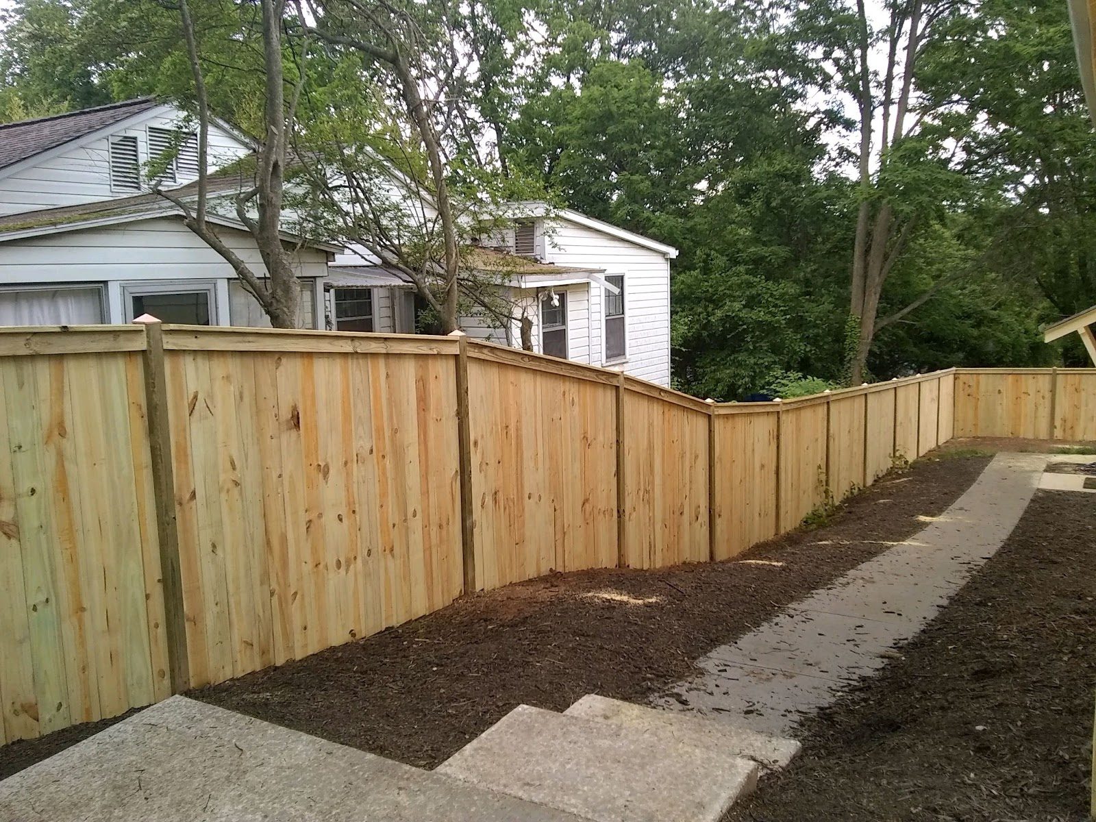 Tall wood privacy fence along a side yard